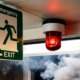 In the middle of survival_feature, youth development: view of emergency exit sign, red alarm light and smoke
