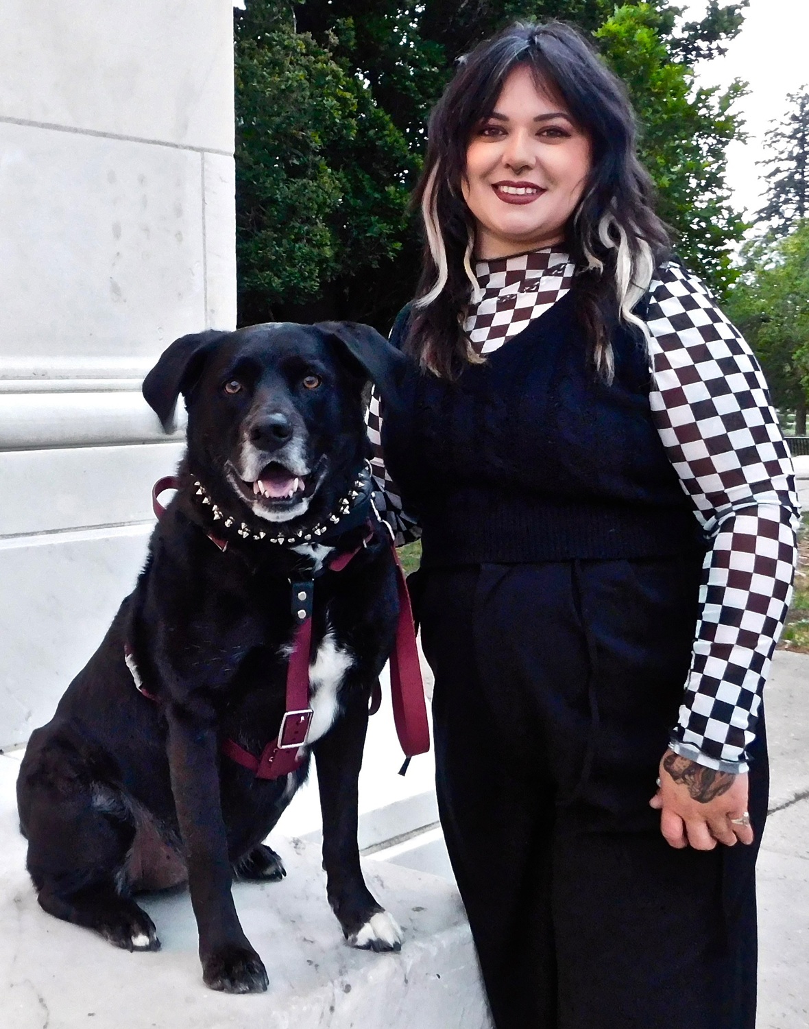 Mentorship for youth with disabilities should be a right, not a matter of chance_Jordon Orona: woman with long colorful hair wearing black and white checkerboard shirt standing next to black dog