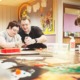 disability-informed mentorship for youth with disabilities should be a right, not a matter of chance_feature: an older man helps a young disabled person at table with task while another disabled person works on their own