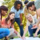 PD vibe check-Where professional learning meets care_feature: group of young staff outdoors pointing at papers on ground doing a team building exercise
