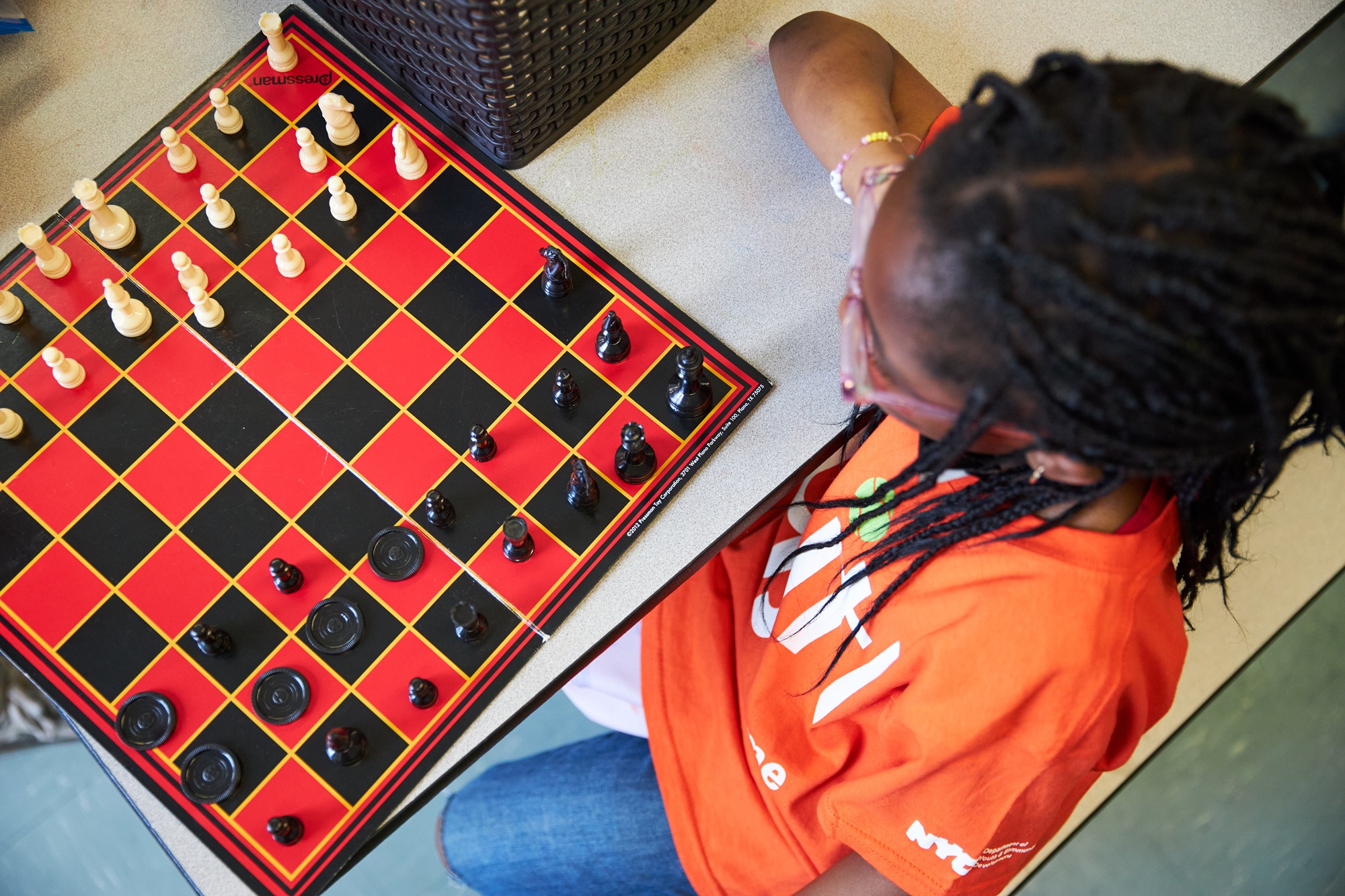 Quality afterschool is worth the investment — It changed my life_chess: top-down view of black youth playing chess
