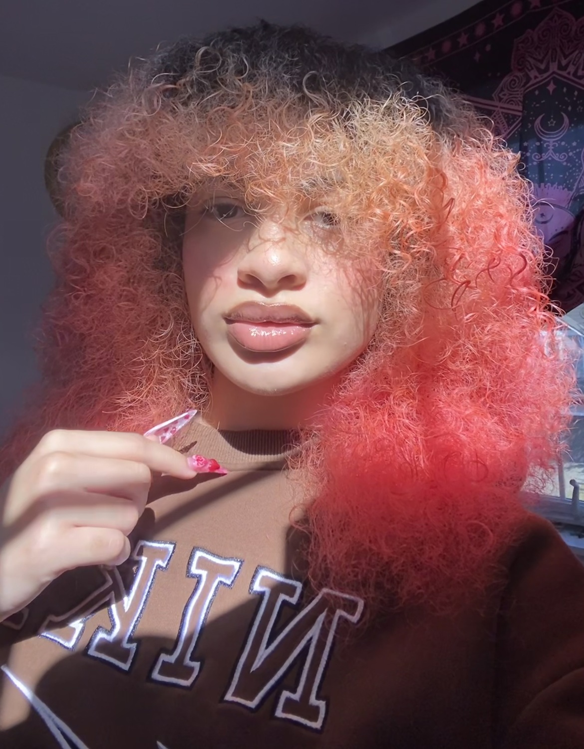 Sahmari Wingo headshot: young woman in Nike sweatshirt with curly red hair