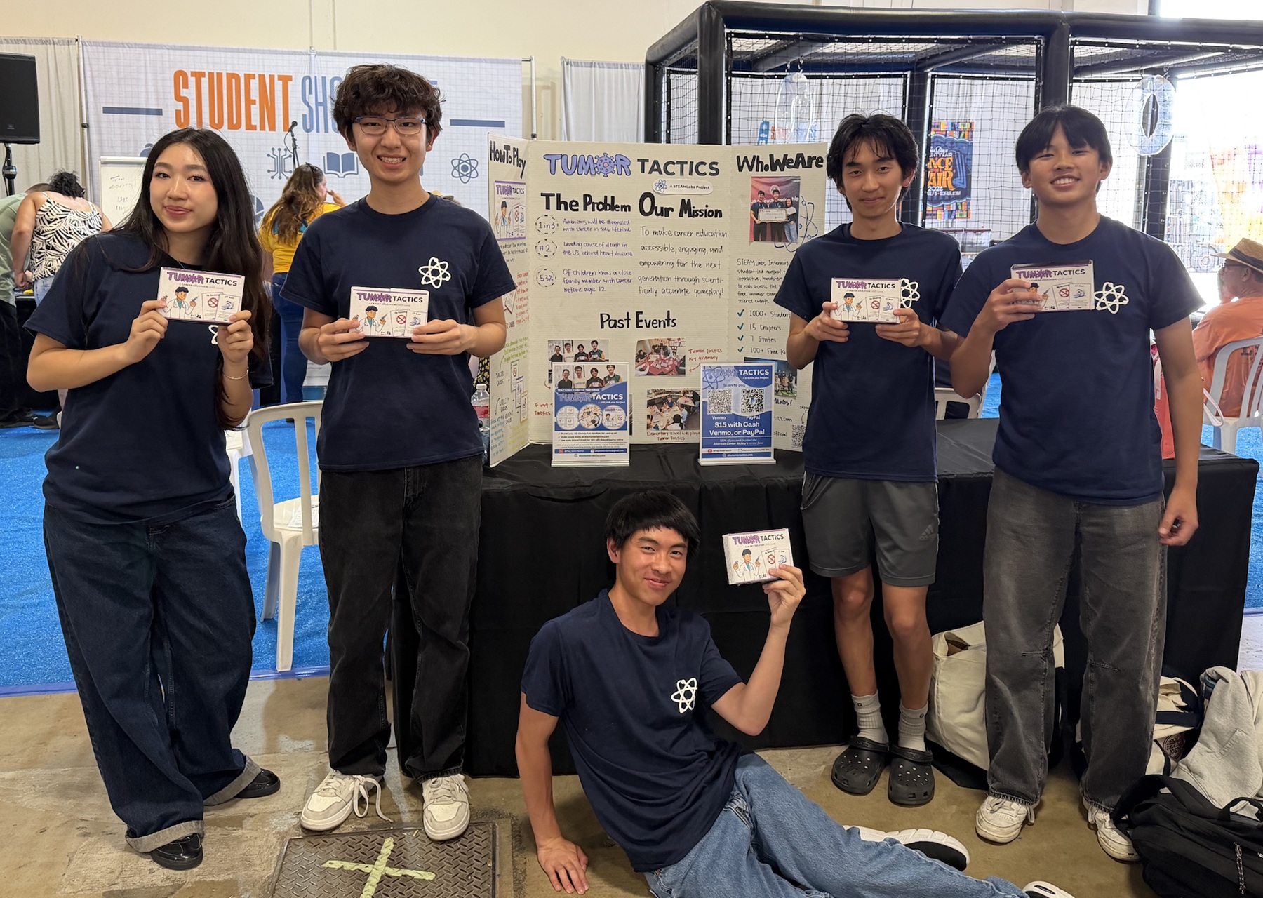 Students don’t just belong in STEAM classrooms-They belong at the front of them_San Diego County Fair: group of youths in matching shirts smile for group photo in front of presentation stand