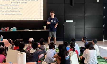 Students don’t just belong in STEAM classrooms-They belong at the front of them_feature: young Asian man stands at the front of a class full of young children teaching with powerpoint