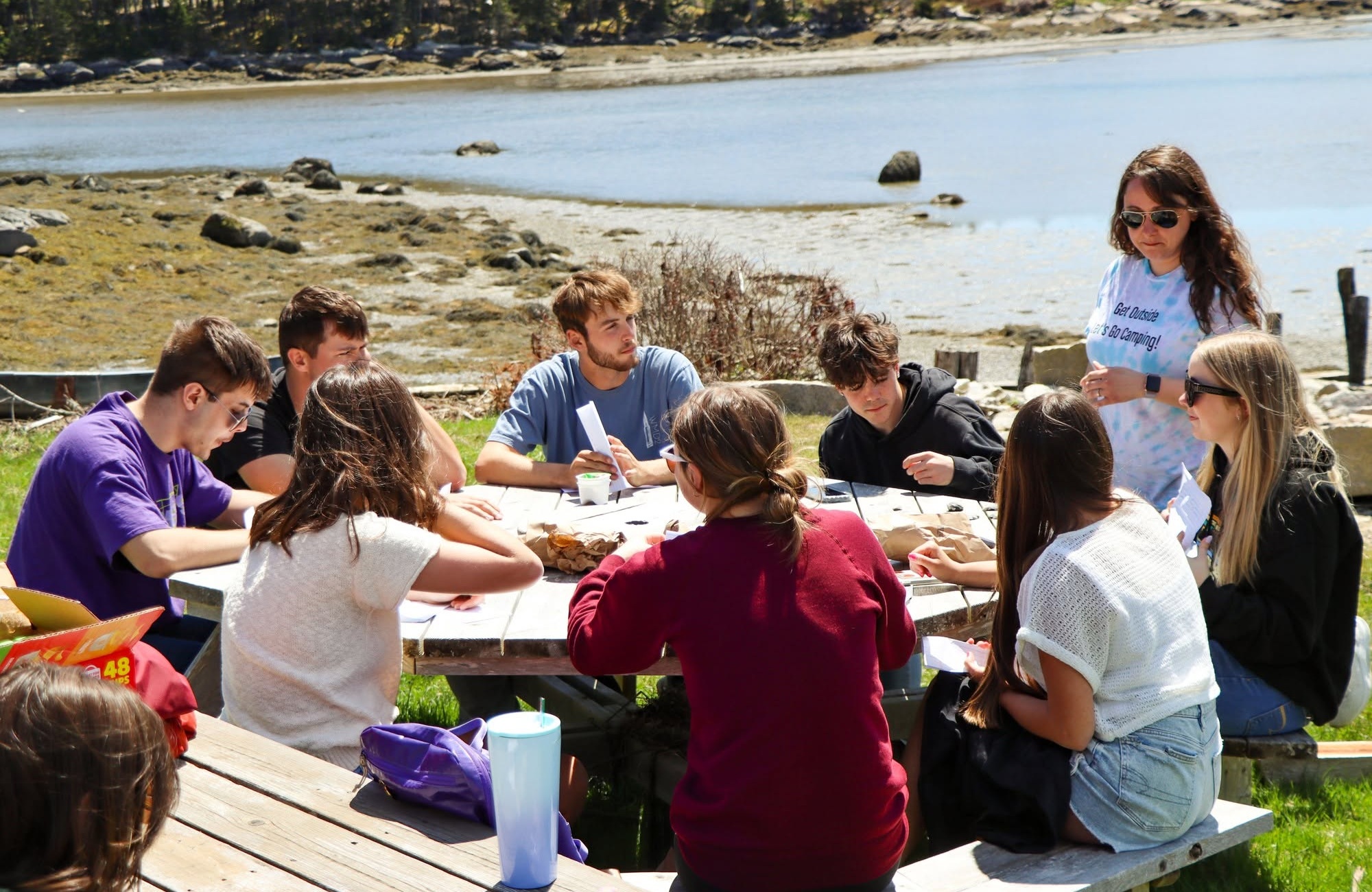Young people need more than safer screens_feature: group of young people at table on coastline