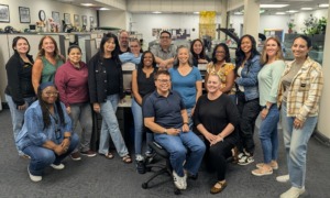 Badges and binders_Records Group Pic: juvenile justice, group of people smiling for photo in office setting