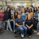 Badges and binders_Records Group Pic: juvenile justice, group of people smiling for photo in office setting