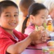 Out-of-school time OST youth development and food insecurity program grants: happy children eating at table outdoors